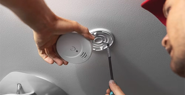 Technician installing a carbon monoxide detector for home safety